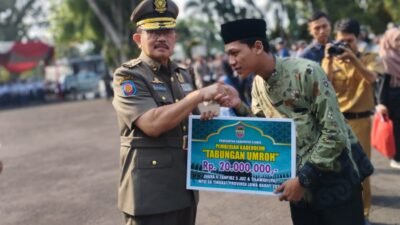 Pj Bupati Ciamis, H. Engkus Sutisna, menyerahkan uang kadeudeuh tabungan umroh secara simbolis. Foto: Febri/berandaperistiwa